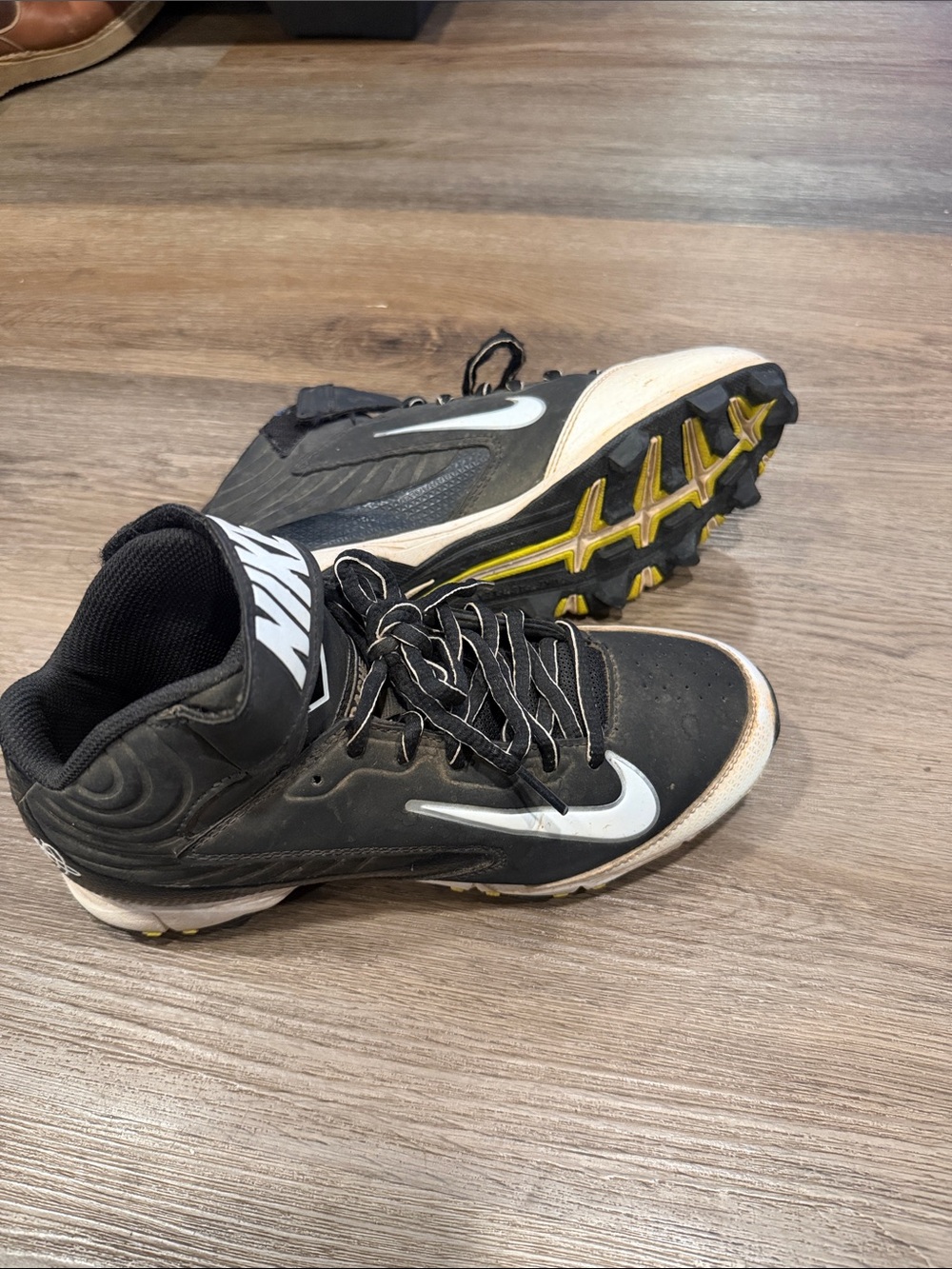 Nike Black and White Kids Athletic Cleats with Yellow Outsole Accents